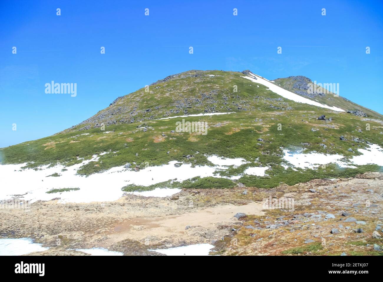 Tateyama Kurobe Alpine Route with beautiful landscape snow mountains., the tourists bus move along the japan alps snow wall with blue sky background. Stock Photo