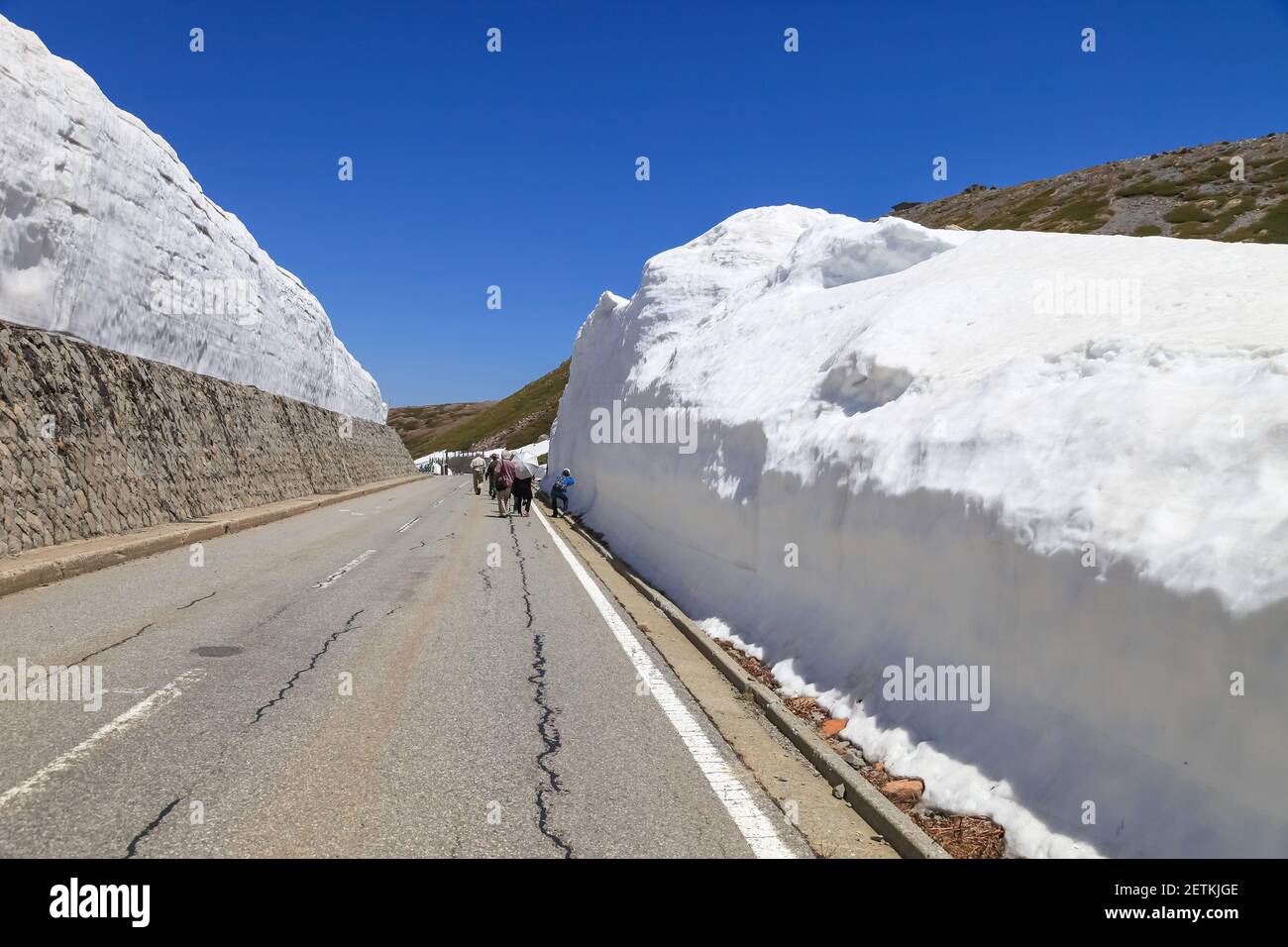 Tateyama Kurobe Alpine Route with beautiful landscape snow mountains., the tourists bus move along the japan alps snow wall with blue sky background. Stock Photo