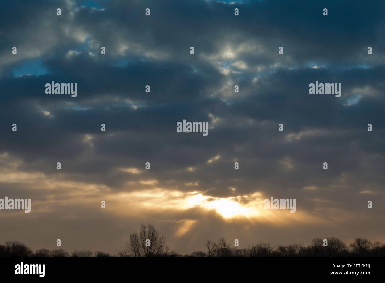 mystical heavenly sky with sun rays coming out from behind clouds Stock Photo