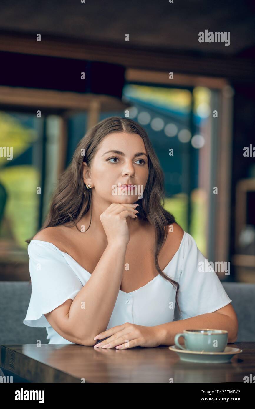 Young adult woman sitting in summer cafe Stock Photo