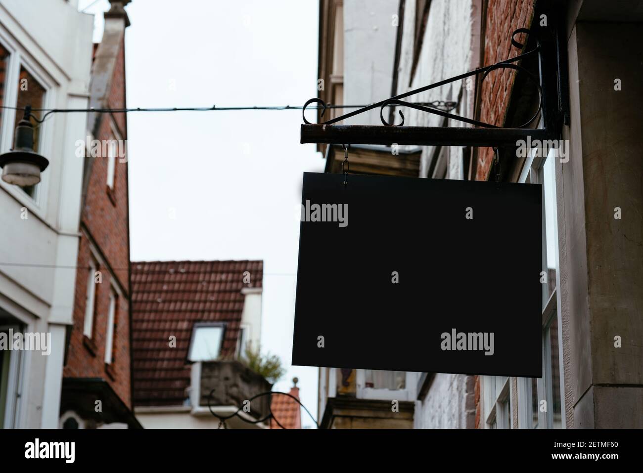 Blank store signage sign design mockup against medieval town. Clear