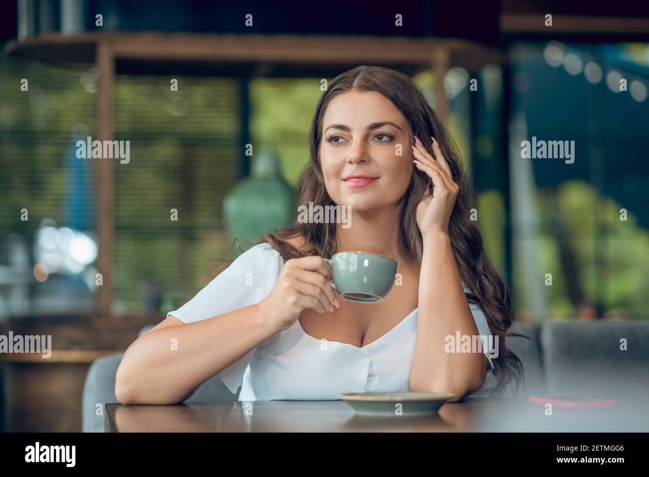 Attractive woman drinking coffee in summer cafe Stock Photo