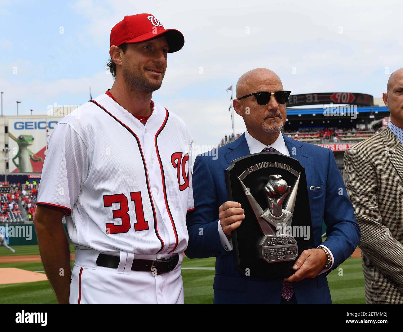 Apr 3, 2017; Washington, DC, USA; Washington Nationals starting pitcher Max Scherzer (31) receives the 2016 National League Cy Young award from general manager Mike Rizzo before the game between the Washington Nationals and the Miami Marlins at Nationals Park. Mandatory Credit: Brad Mills-USA TODAY Sports *** Please Use Credit from Credit Field *** Stock Photo
