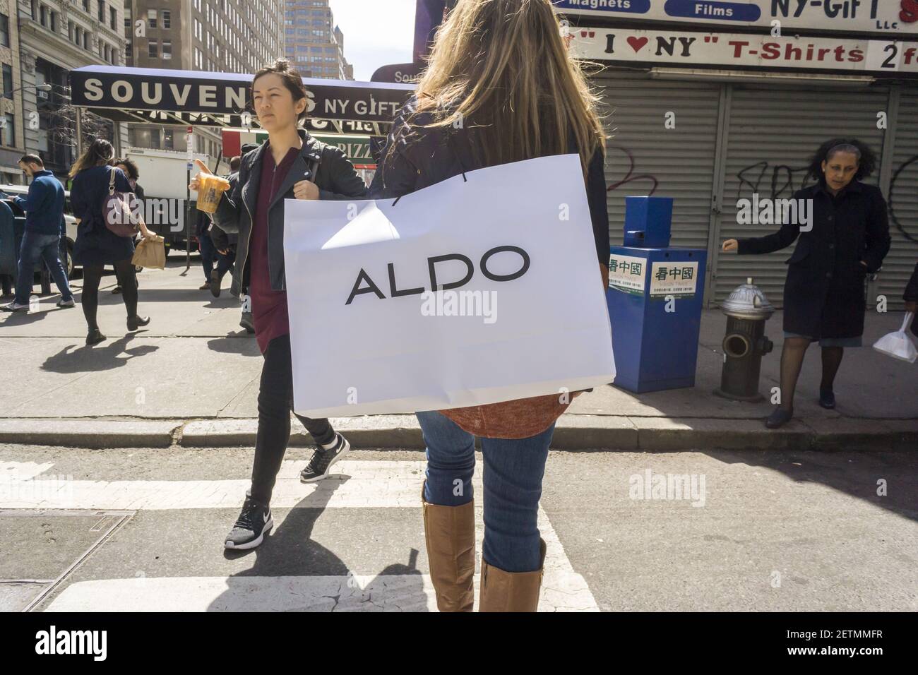 A shopper walks with a shopping bag containing her purchase from an Aldo store in New York on Monday April 3 2017. Aldo a Canadian company operates a chain of almost 2 150
