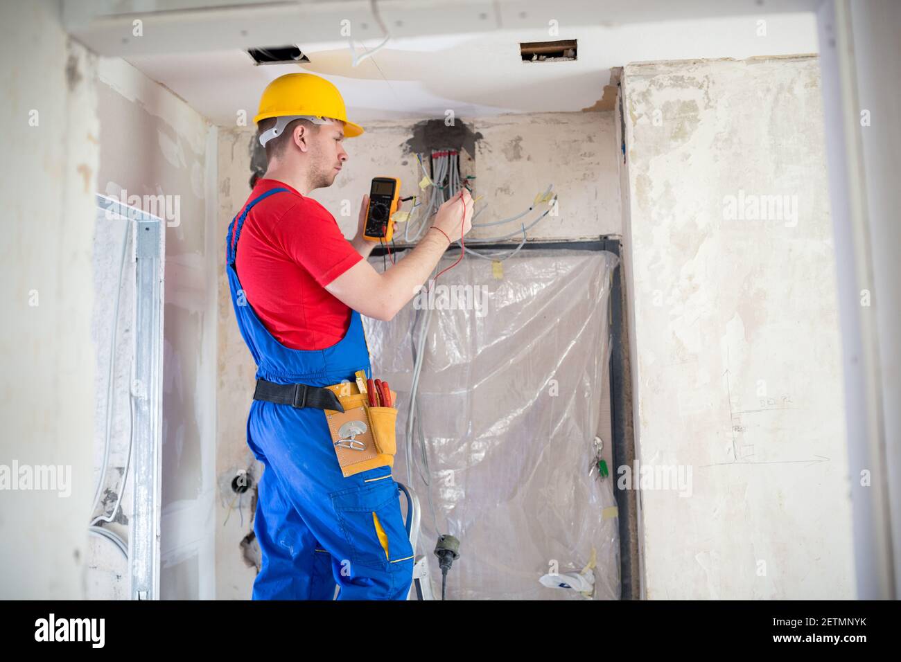 Skilled electrician using unimer for voltage checking Stock Photo