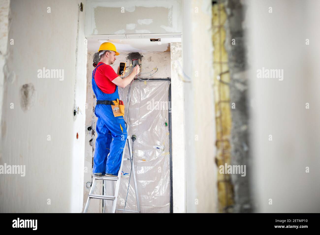 Skilled electrician using unimer for voltage checking Stock Photo