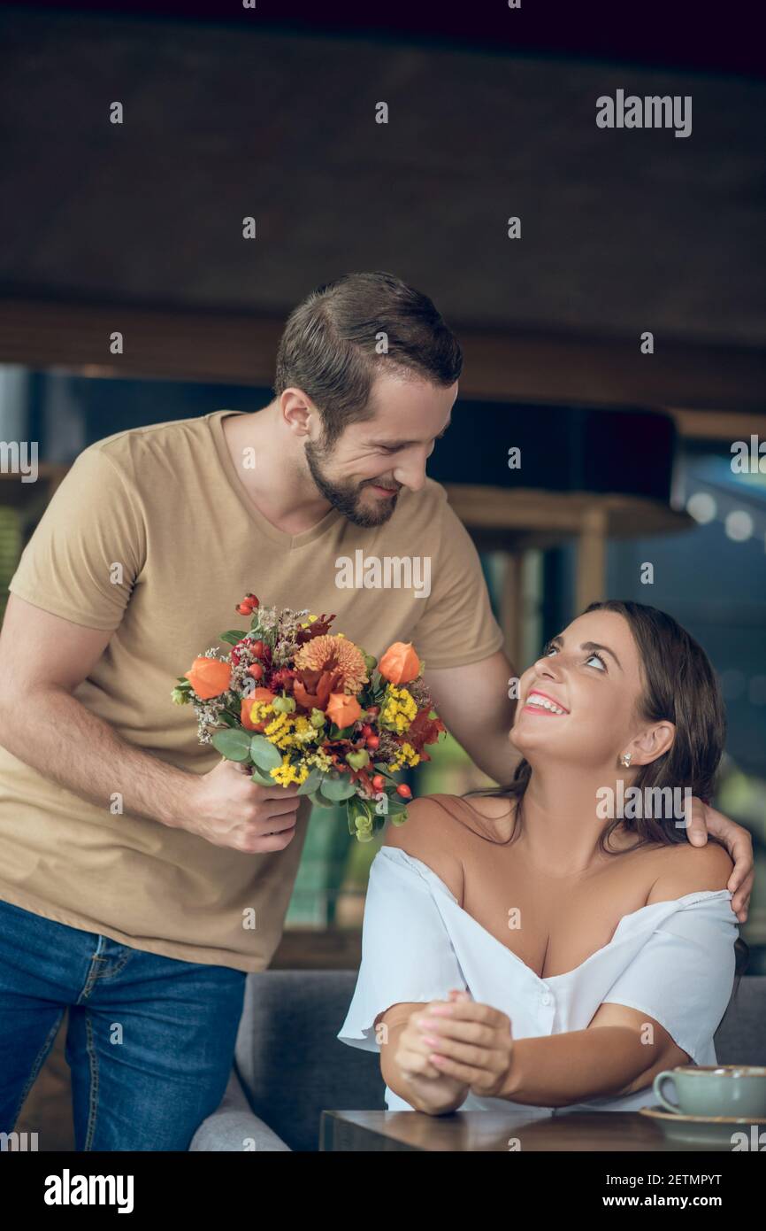 Enamored man with flowers and happy woman Stock Photo