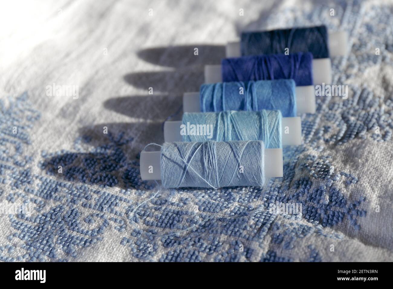 Bobbin Blue thread. Set of sewing thread coils on white natural fabric ...