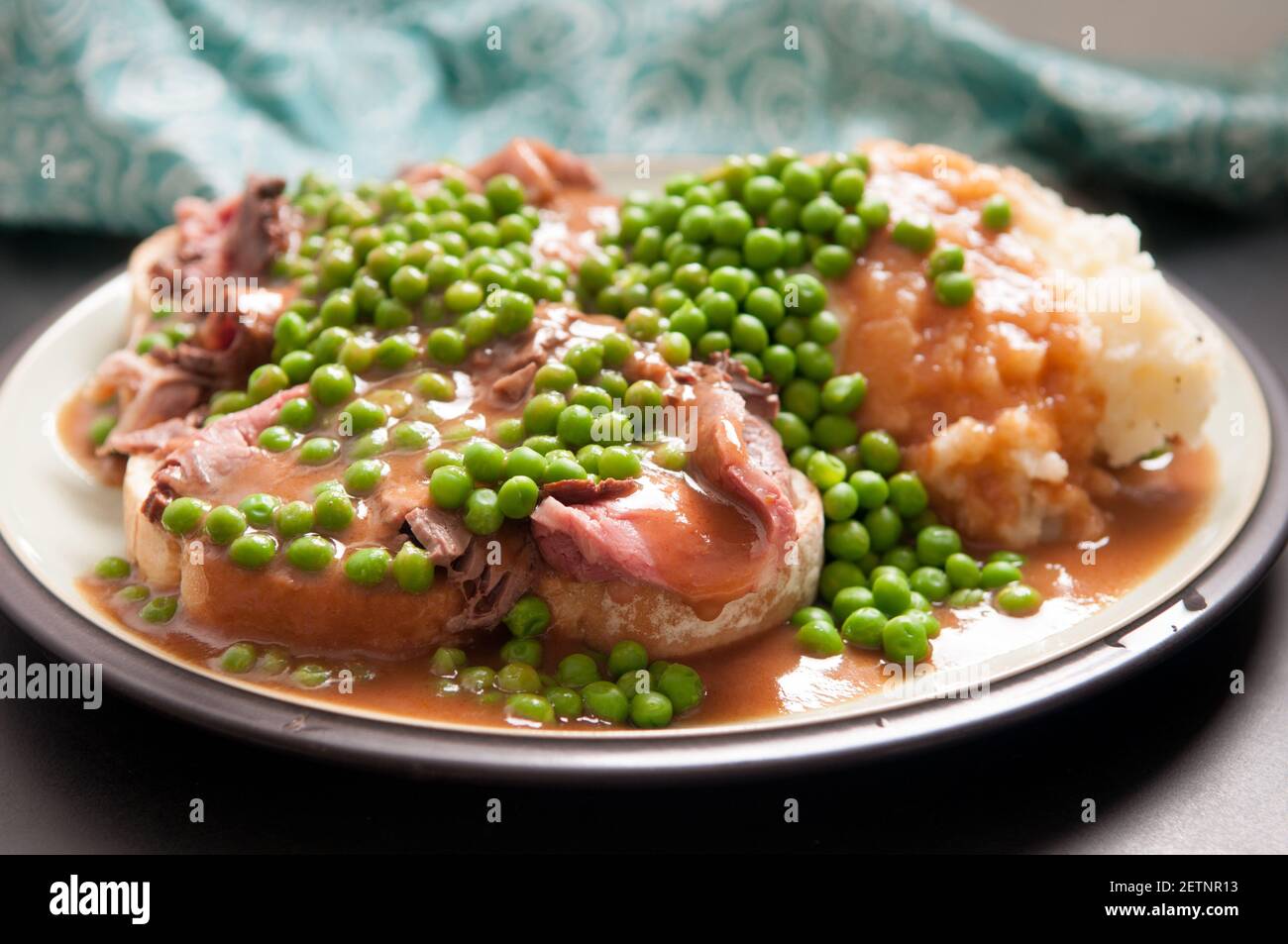 open faced hot roast beef sandwich with mashed and gravy and peas Stock Photo Alamy
