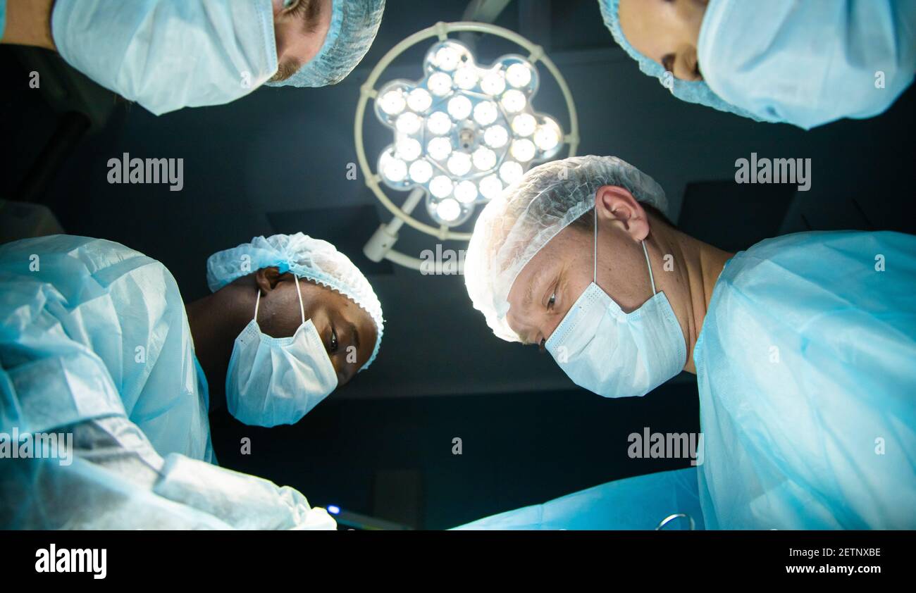 The faces of doctors in medical masks from the bottom up during a
