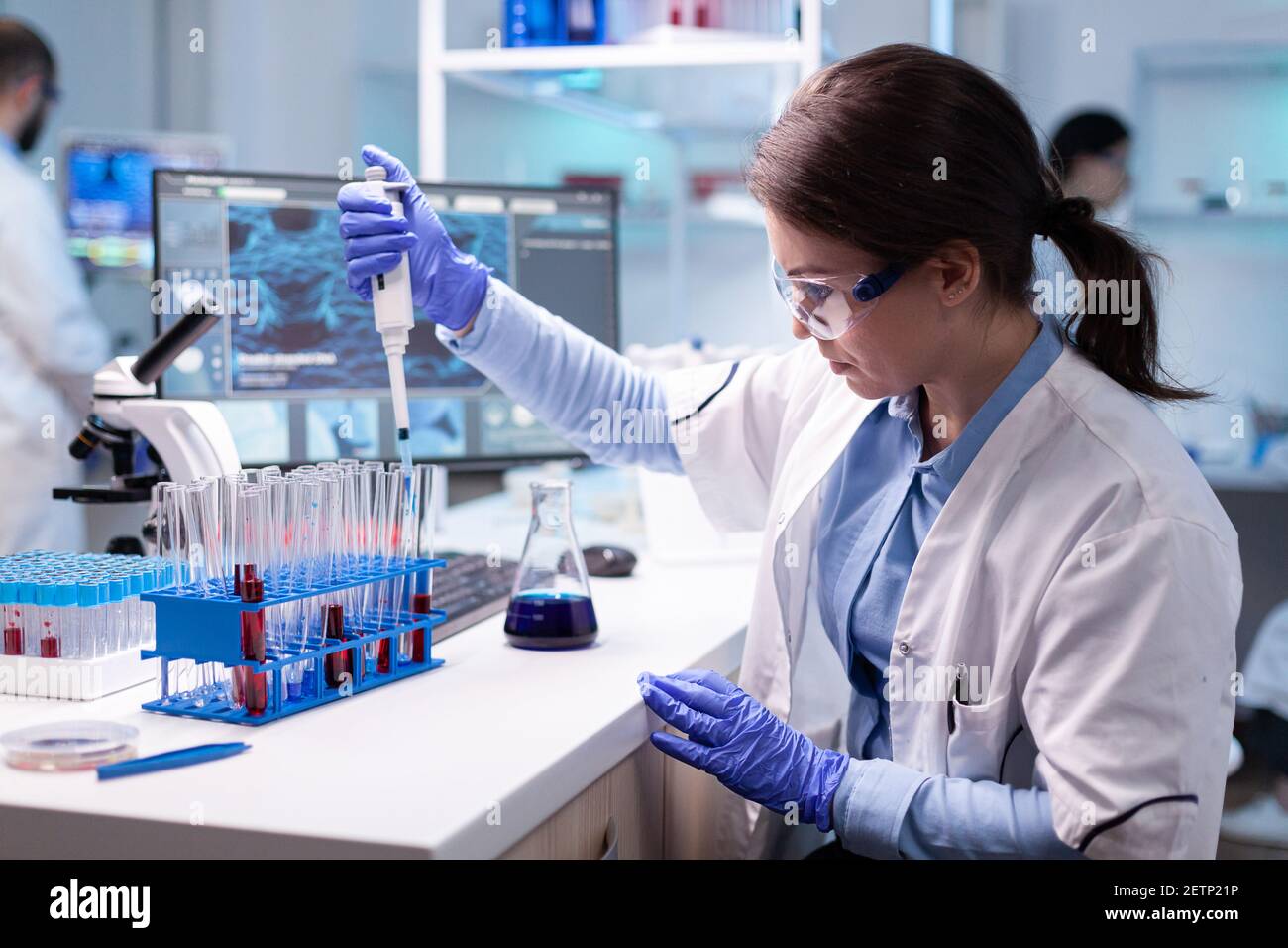 Concentrated professional woman scientist in laboratory working with a