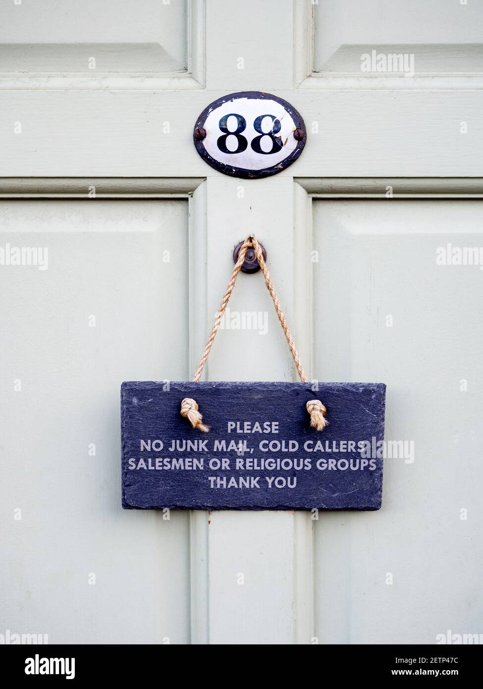 Slate sign hanging on a front door warning, No Junk Mail, No Cold Callers No Salesmen, No Religious Groups; Olney, Buckinghamshire, UK Stock Photo