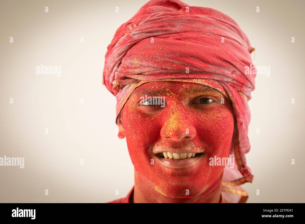 PORTRAIT OF A YOUNG MAN WITH COLOURS ALL OVER HIS FACE LOOKING AT CAMERA Stock Photo