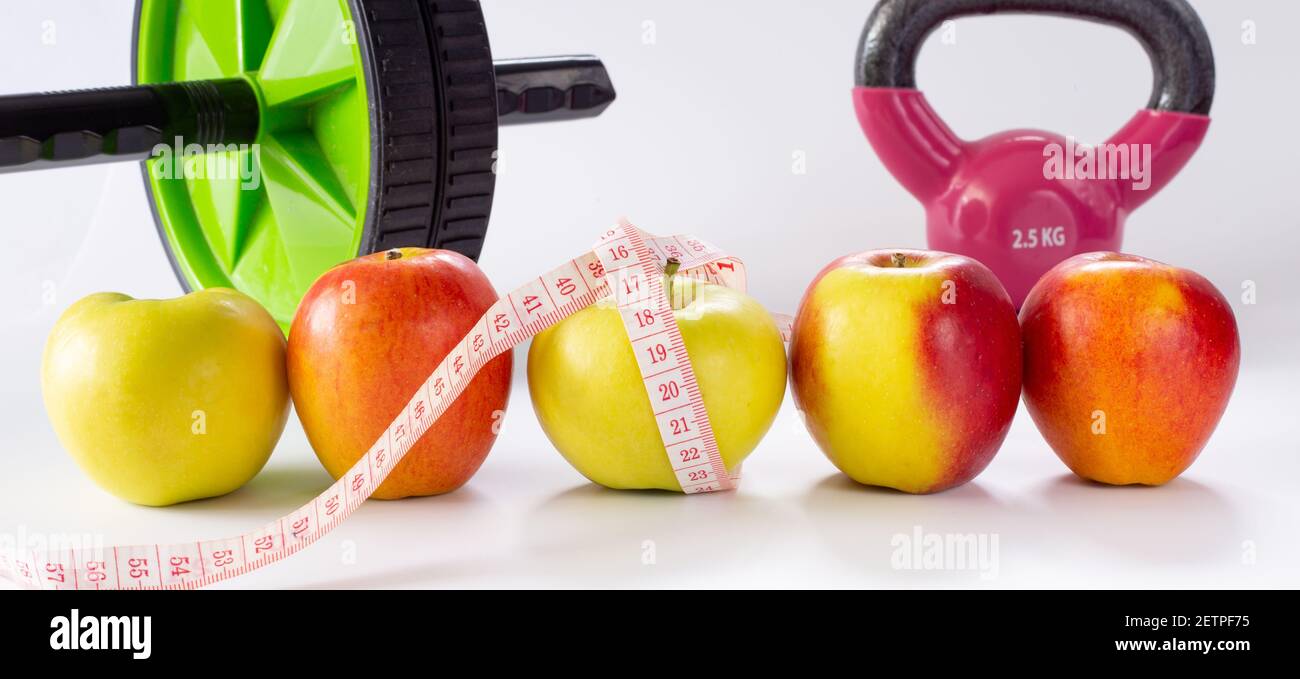healthy life fitness. Diet and Healthy life Concept. Apples, measure tape, sport home gym equipment kettle bell, ab roller for women diet slimming Stock Photo
