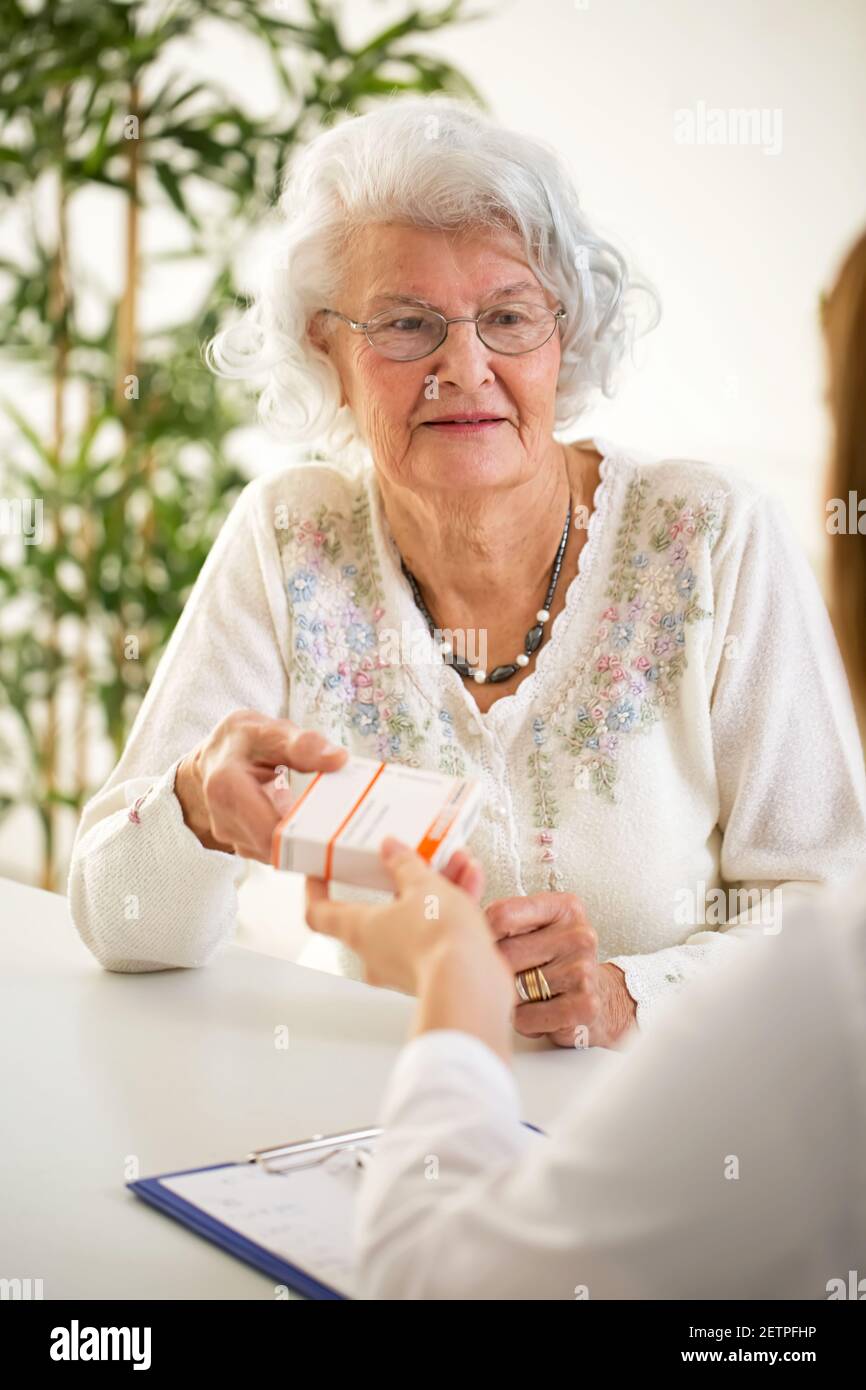 Doctor giving prescription smiling woman hi-res stock photography and ...