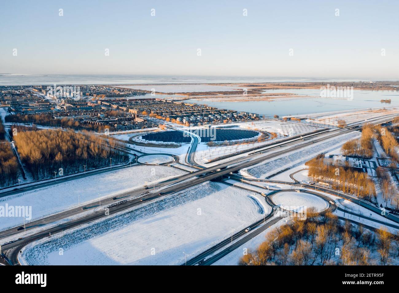 Modern sustainable neighbourhood surrounded by nature in Almere, The Netherlands, powered by solar energy. Winter landscape. Aerial shot. Stock Photo