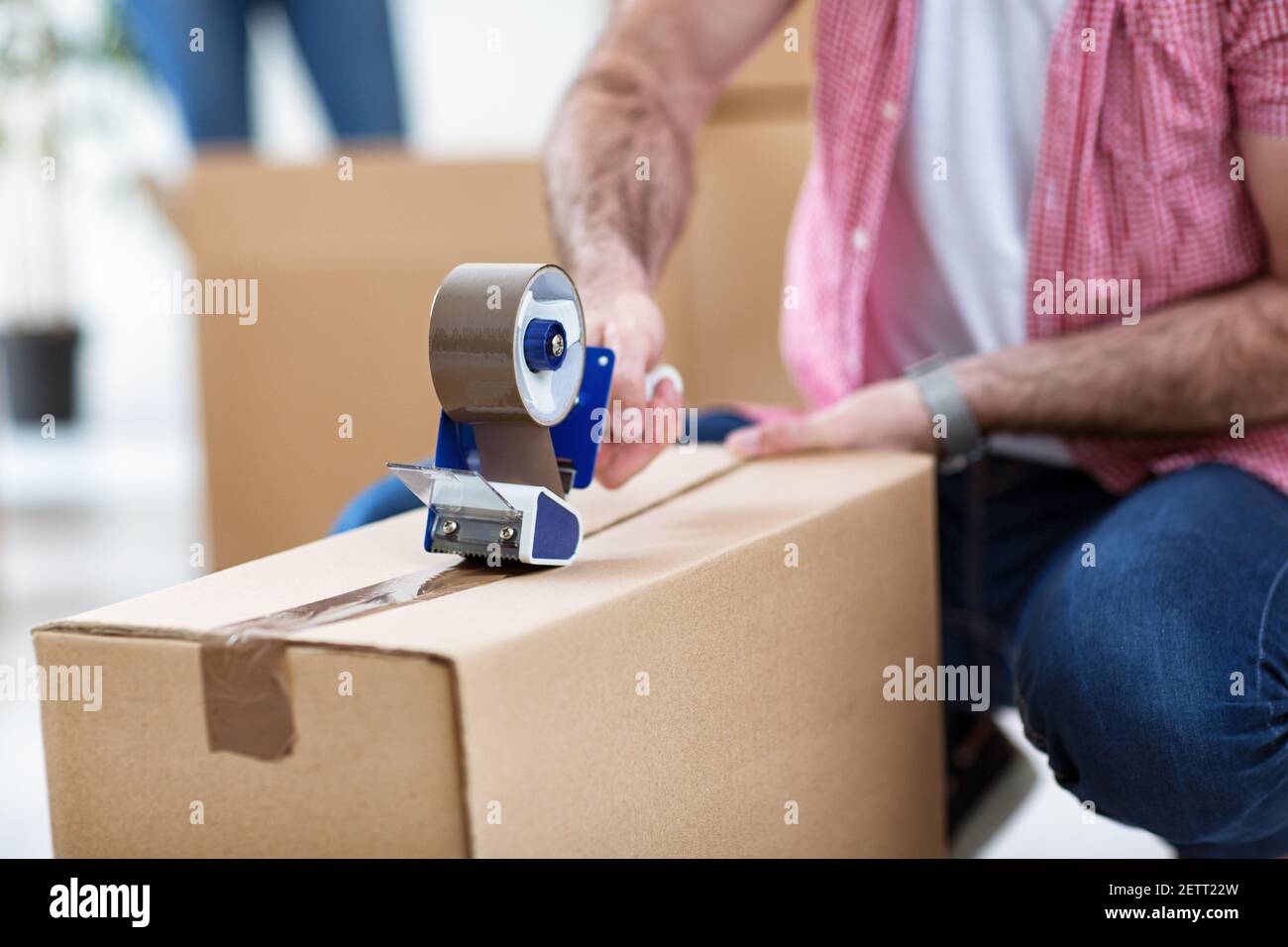 Packing things in boxes for moving at new apartment Stock Photo