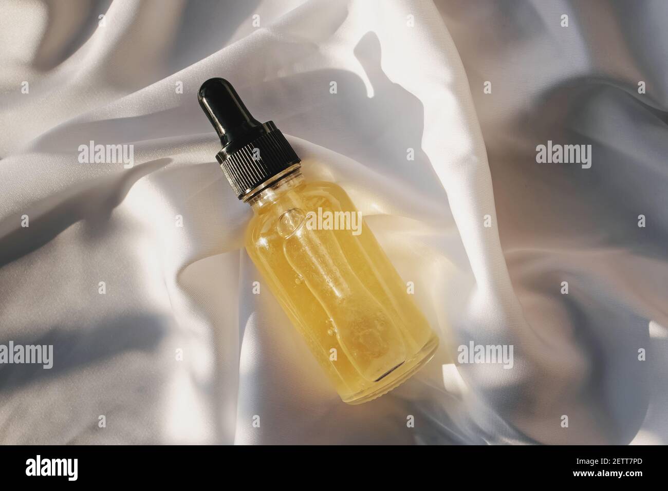 Small glass bottle with eyedropper on white cloth Stock Photo