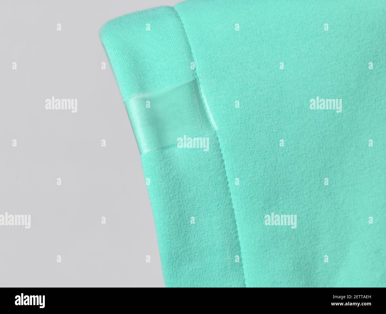 Closeup of modern mint color hood, cowl top fabric with blank transparent label ready to copy paste Stock Photo