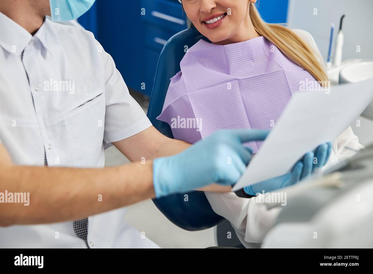 Dental practitioner displaying xray results to female patient Stock