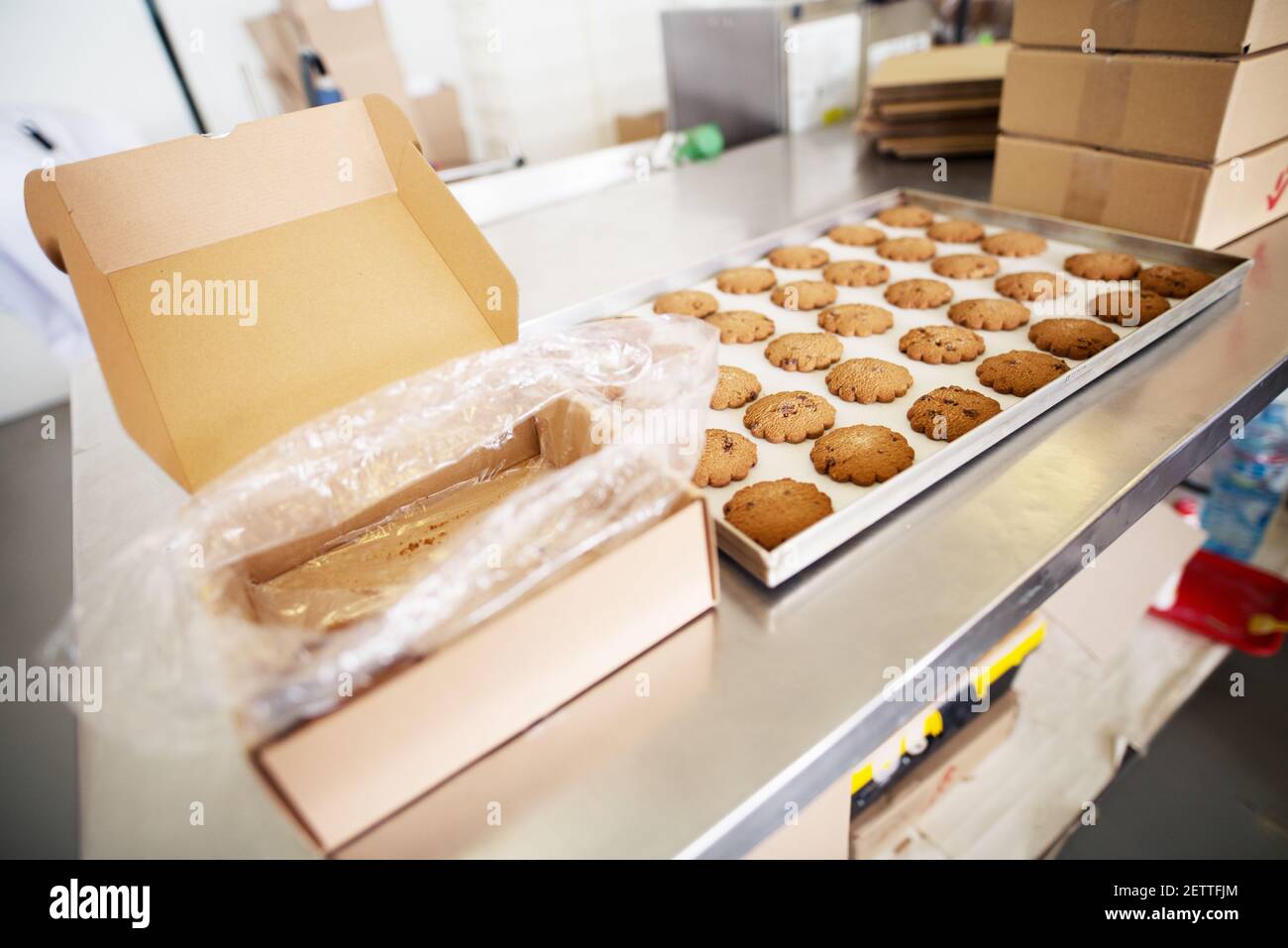 Warm freshly baked cookies cooling on a desk inside of food production ...