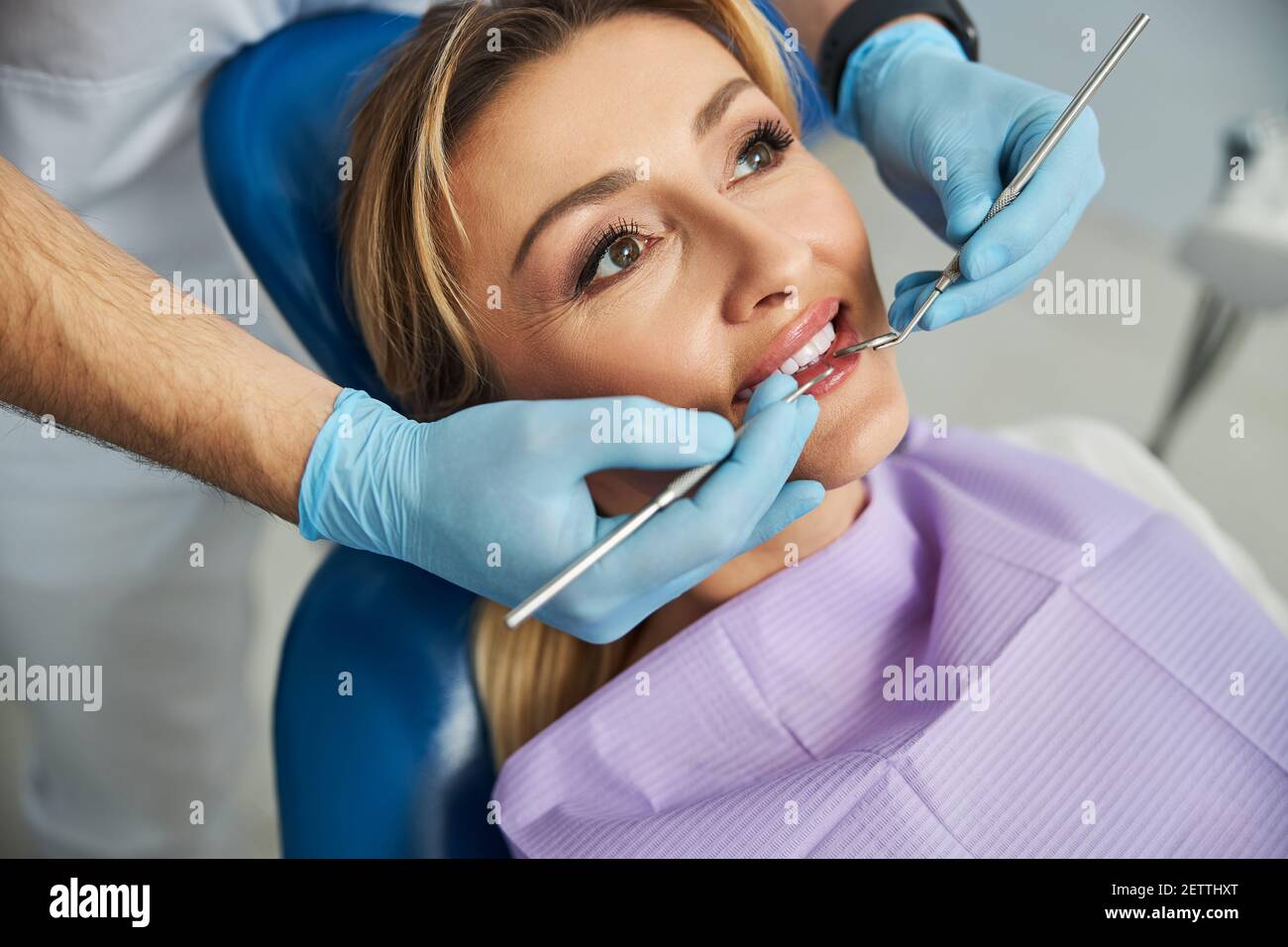 Dentist touching patient teeth with stomatological tools Stock Photo