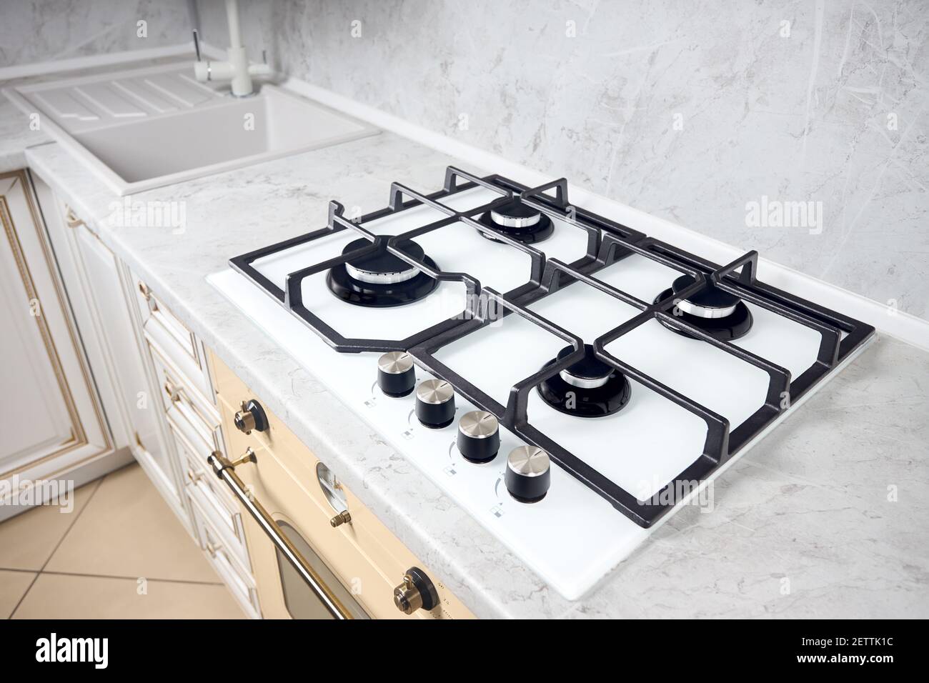 Modern white gas stove on counter top closeup. Hob gas stove made of tempered white glass using