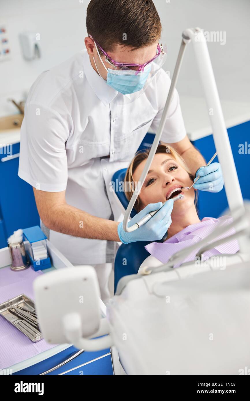 Dentist drilling woman teeth during oral dental procedure Stock Photo