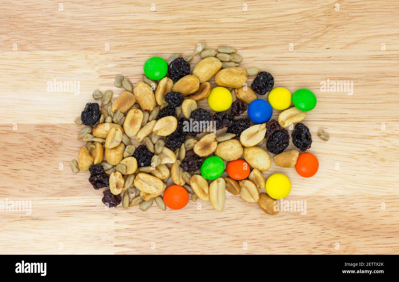 Sweet and salty trail mix portion on a wood countertop overhead view