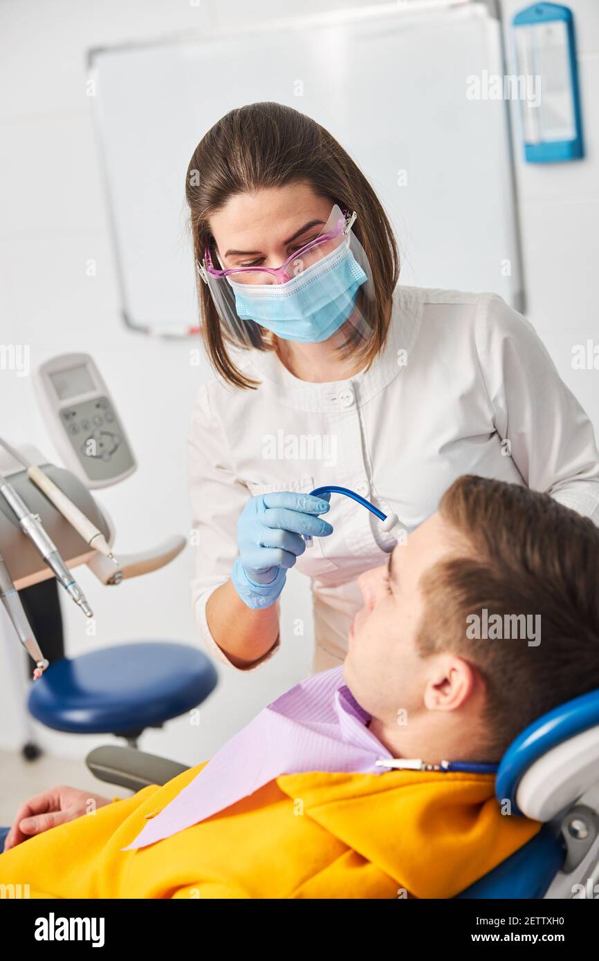 Stomatologist directing saliva ejector to man mouth Stock Photo Alamy