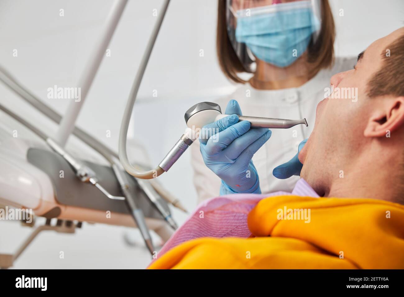 Turbine dental instruments going into patient mouth with dental dam