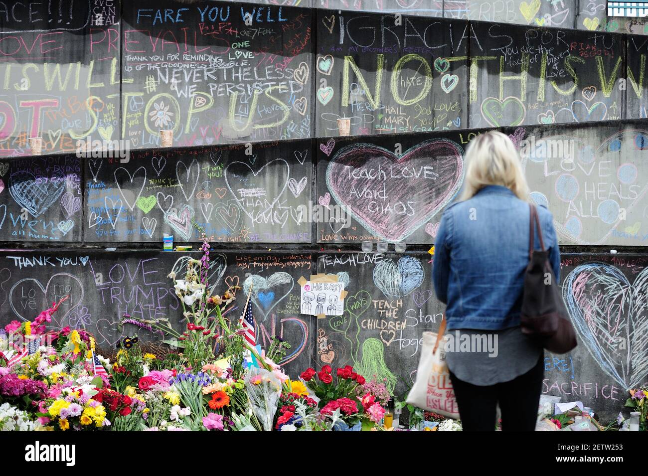 A woman reads messages at a memorial in Portland, Ore., on May 30, 2017 ...