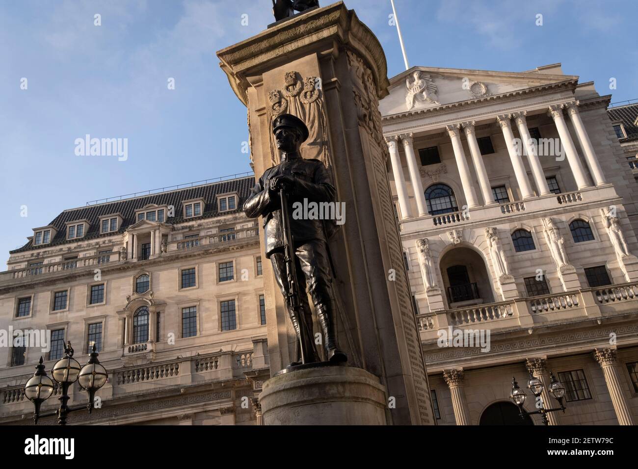 The figure of a fallen soldier of the First World War and an exterior of the Bank of England in the City of London, on 1st March 2021, in London, England. Stock Photo