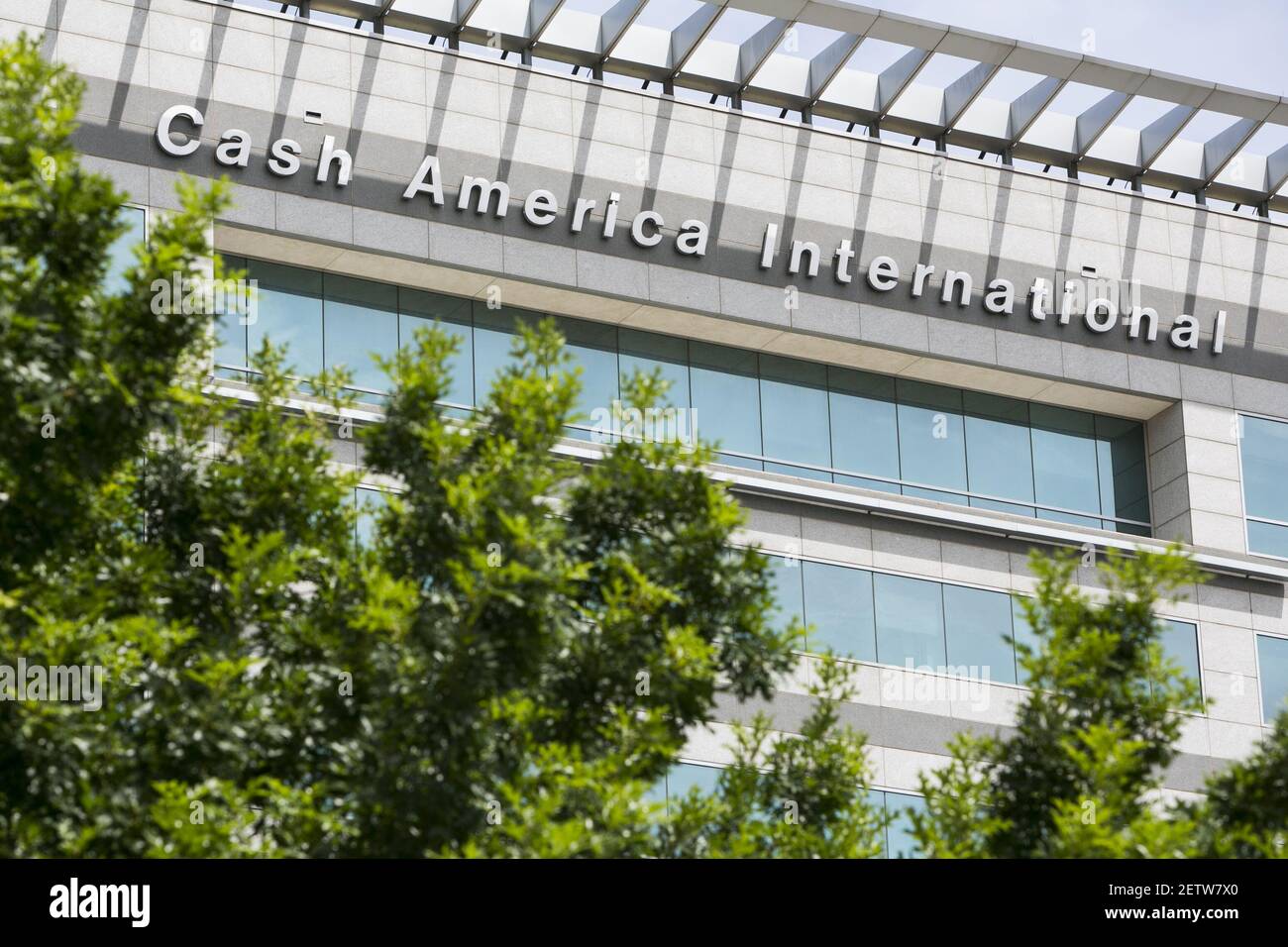 A logo sign outside of the headquarters of Cash America International