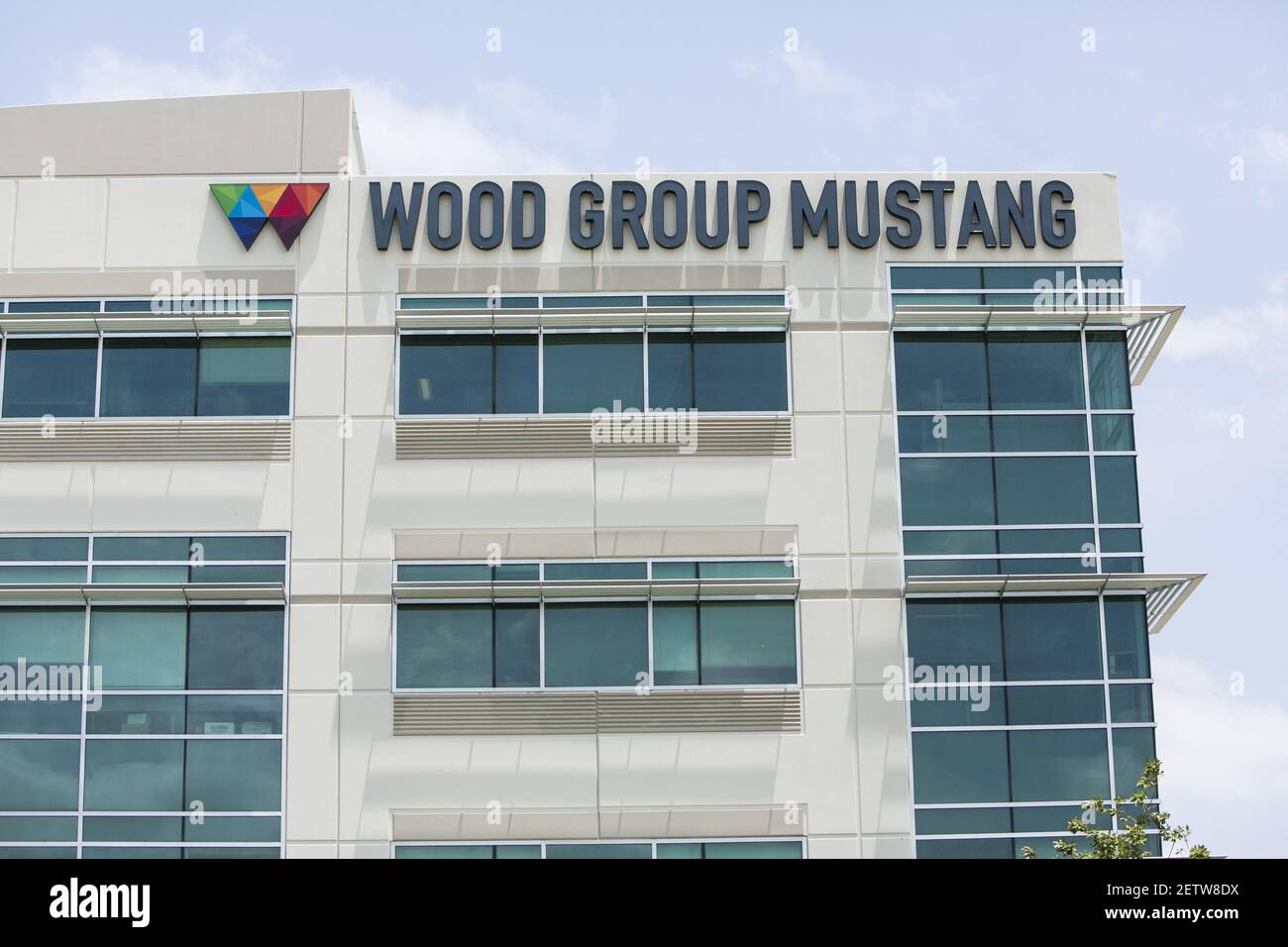 A logo sign outside of the headquarters of Wood Group Mustang, Inc., in