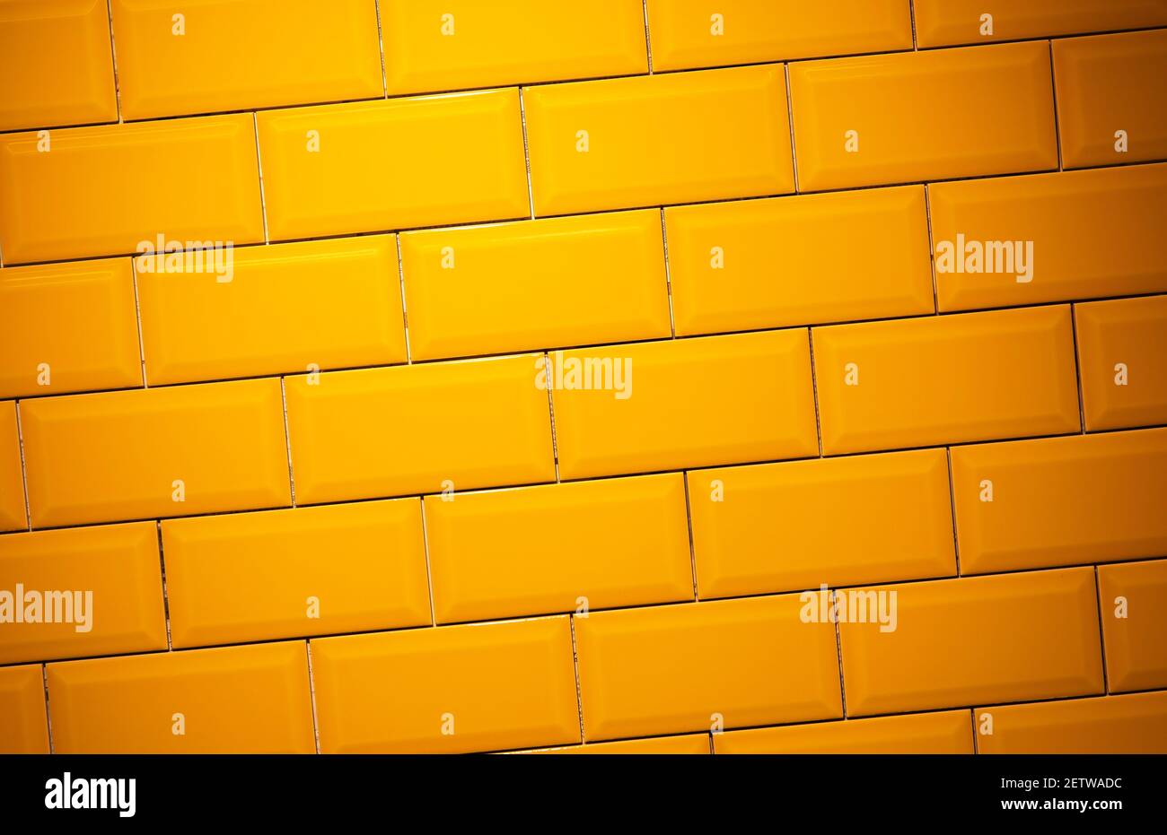 Yellow, glossy ceramic floor tile brick wall texture background Stock