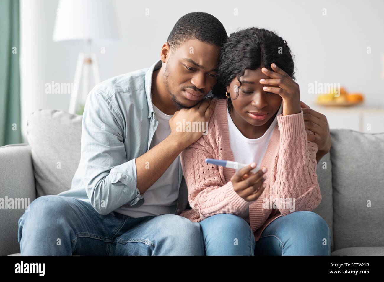 Upset black couple with negative pregnancy test at home Stock Photo