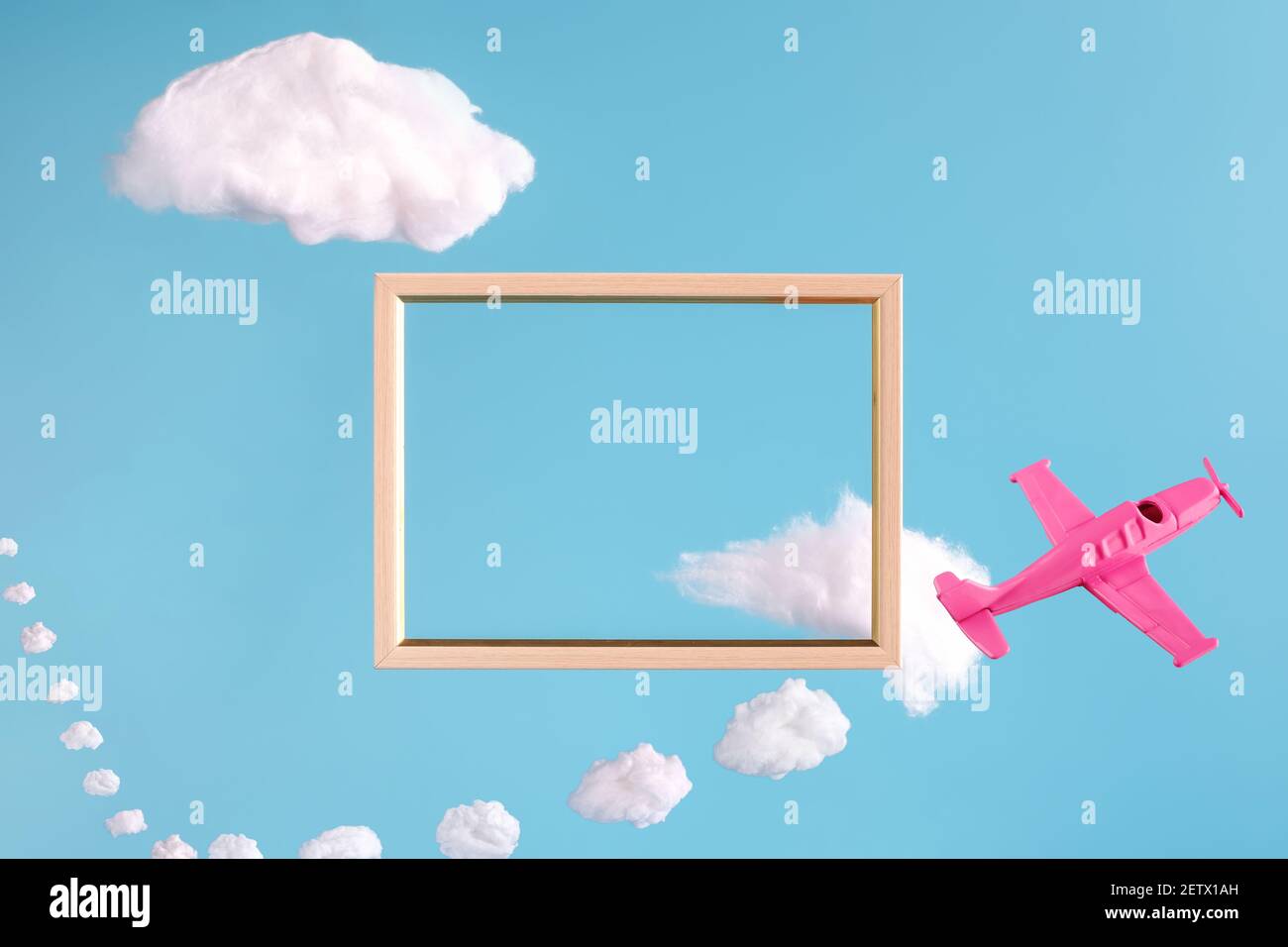 frame on blue background with abstract clouds and pink airplane Stock Photo