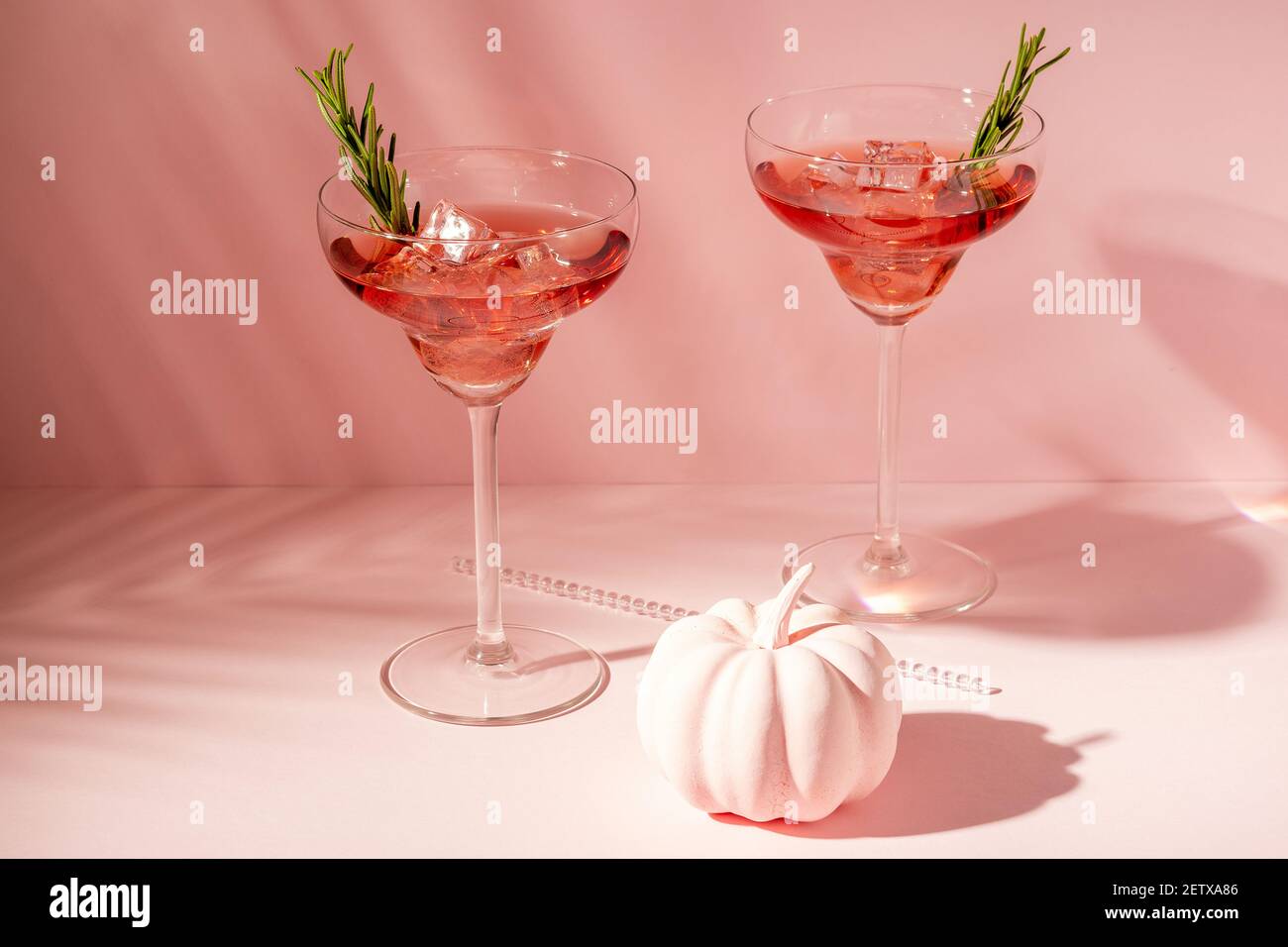 Halloween minimal concept with pink pumpkin and cocktails. Creative holiday party background. Stock Photo