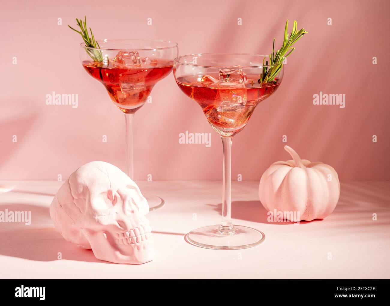 Halloween minimal concept with pink pumpkin, skull and cocktails. Creative holiday party background. Stock Photo