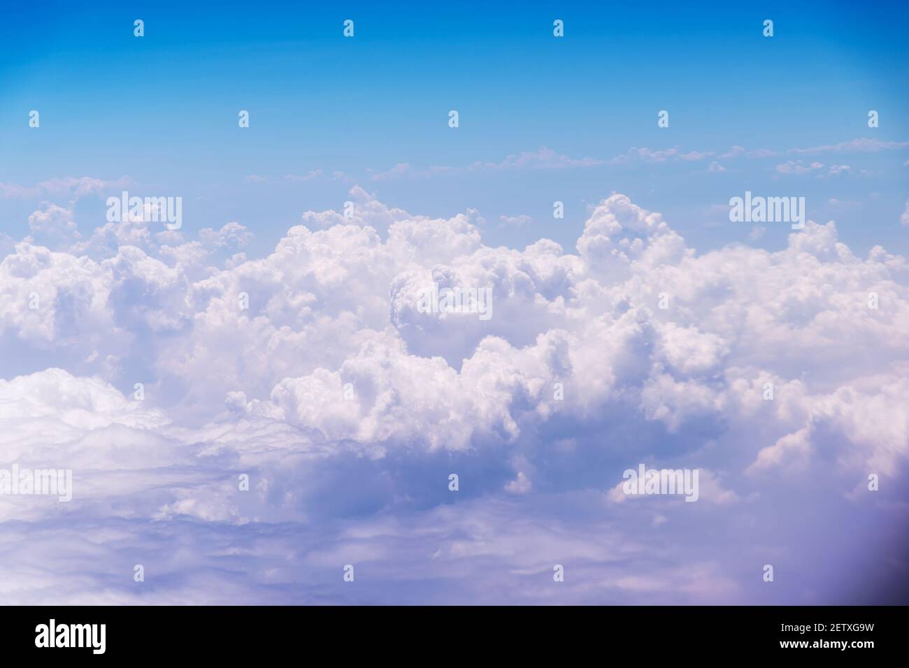 White clouds against blue sky view through an airplane window for a ...