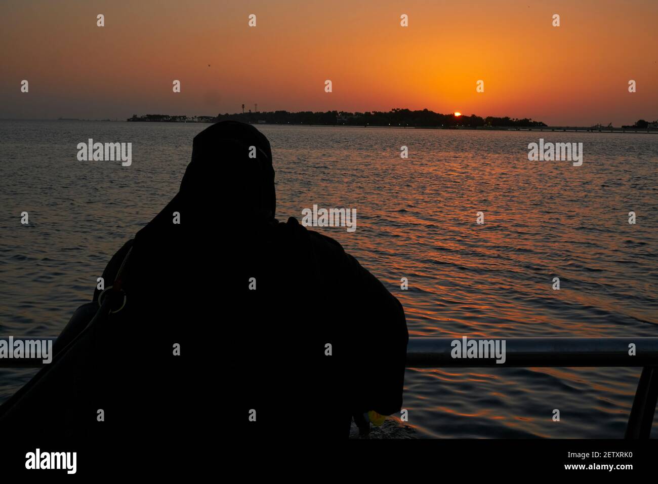 An Arab woman watches the sunset Stock Photo