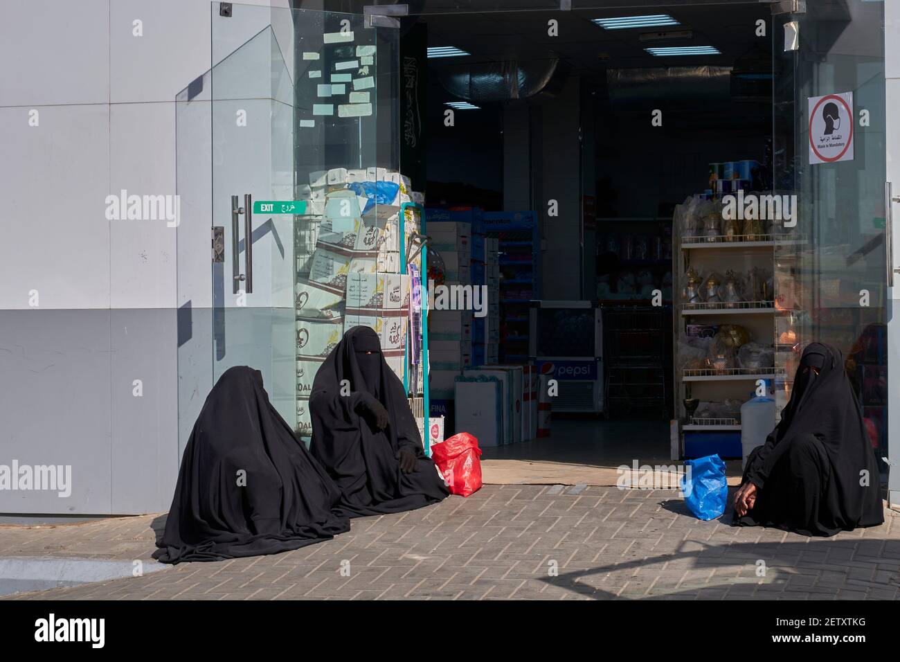 Arab women begging in a food store Stock Photo
