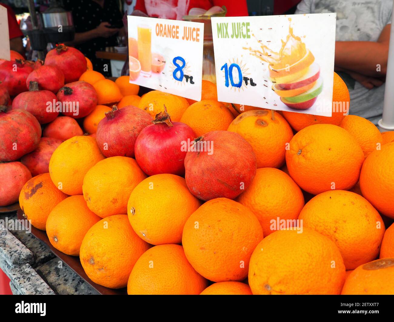 Oranges and pomegranates on counter of local market with price tags for making juice: Istanbul, Turkey - August 22, 2018 Stock Photo