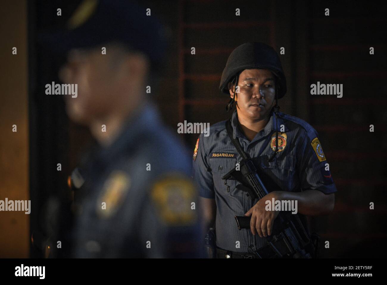 Police officers stand guard at the scene of a shooting victim in Quezon ...