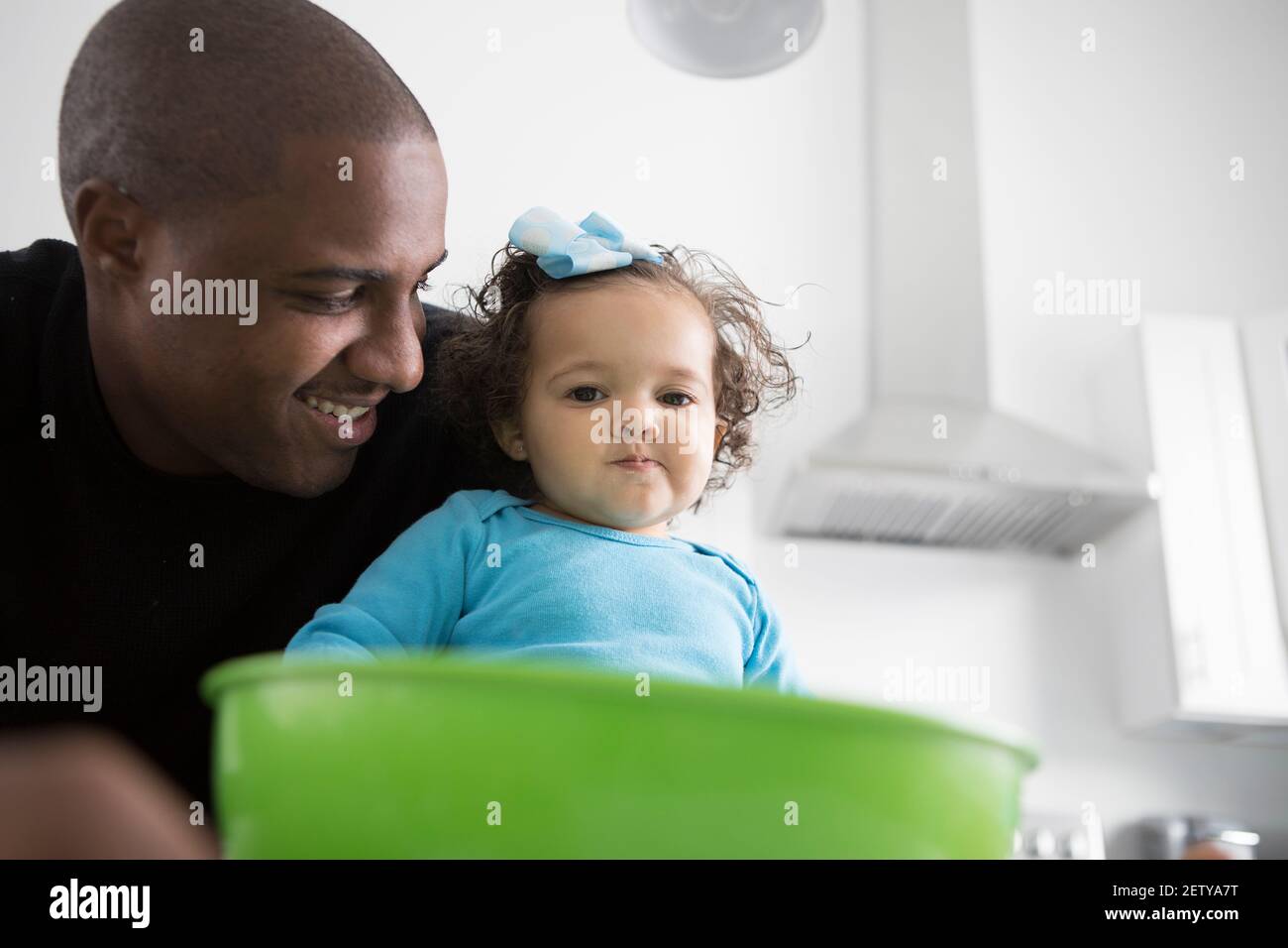 A Dad spends time in the kithchen with his daughter. They are baking, Stock Photo