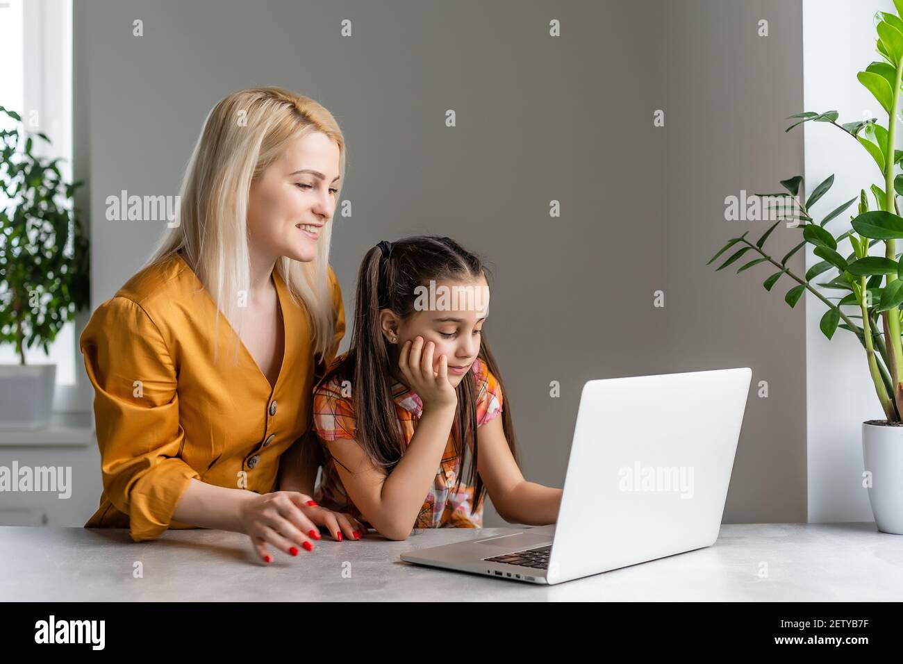 Helpful mother explaining to daughter about using a laptop Stock Photo