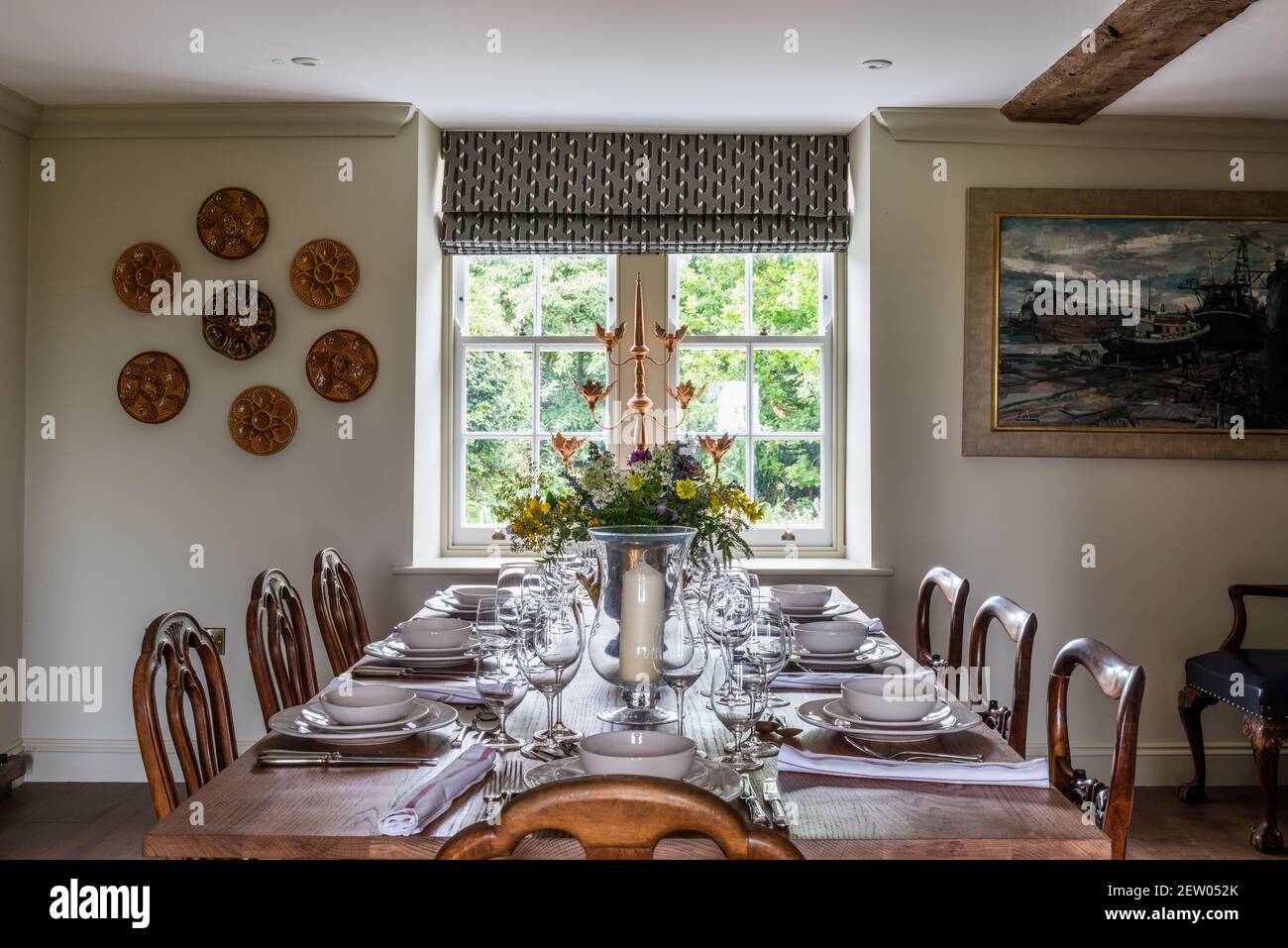 Table for eight at window in off-grid farmhouse renovation. Stock Photo