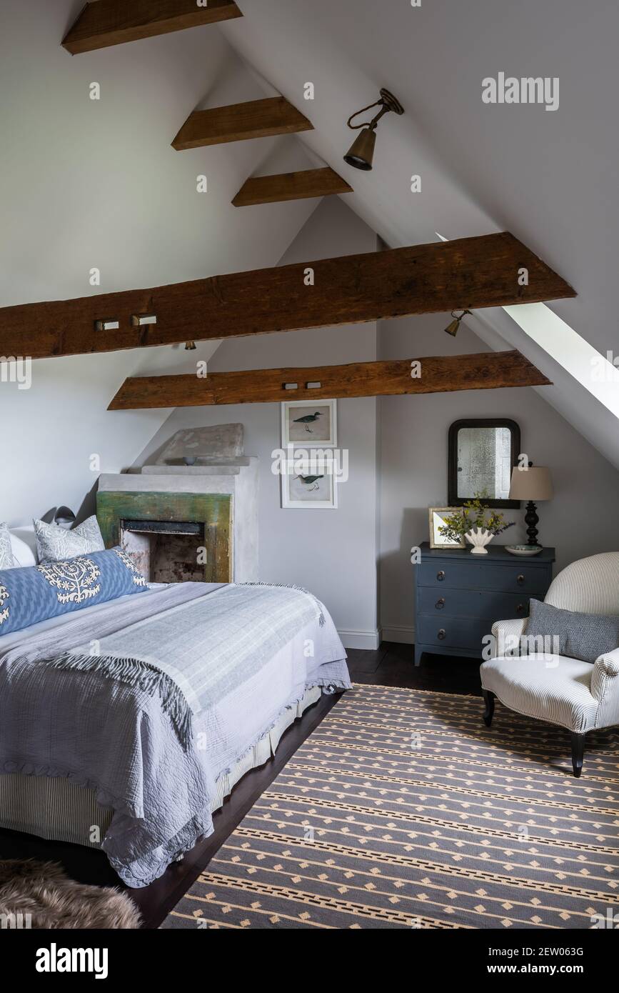 Attic bedroom by Tom Dunn in off-grid farmhouse renovation. Stock Photo