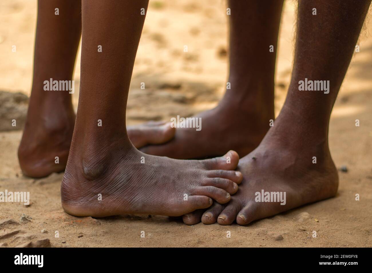 a tribal son playing with his father by feet. Stock Photo